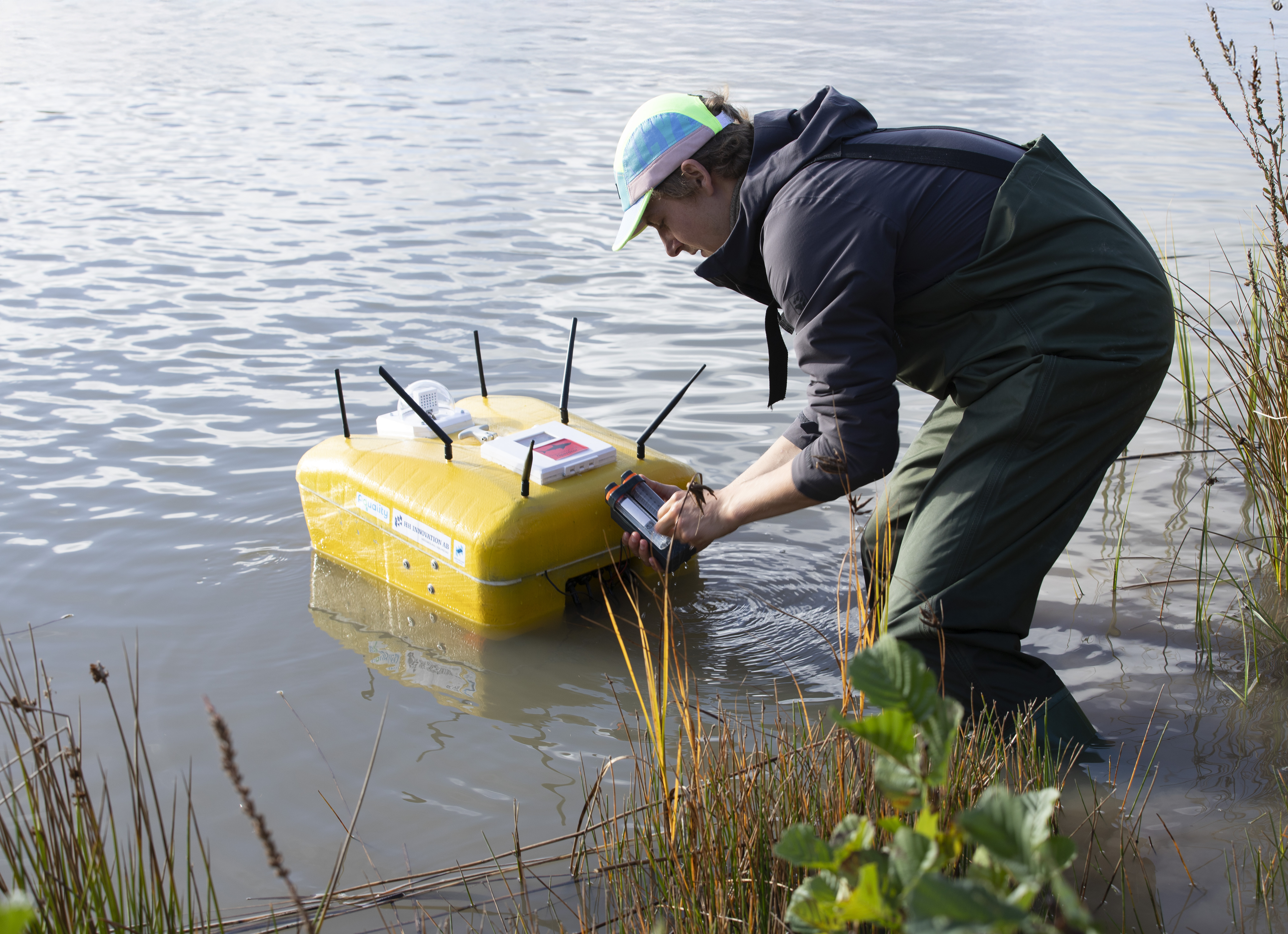 Researcher configuring the AqualityONE Operator USV at the basin bank